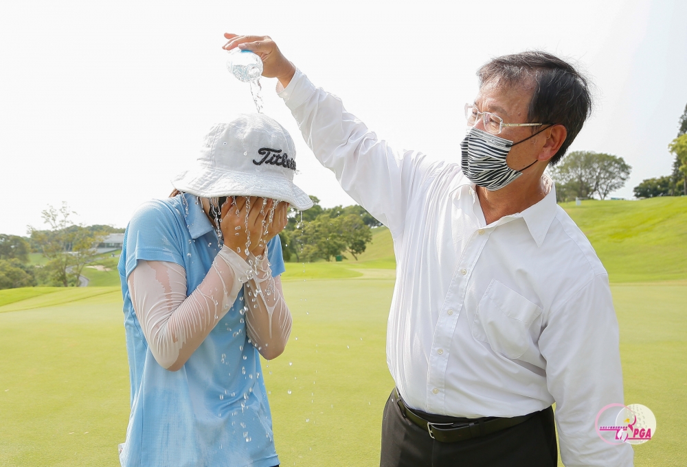 冠軍洪玉霖接受建大工業股份有限公司董事長楊啓仁(右)潑水慶祝。