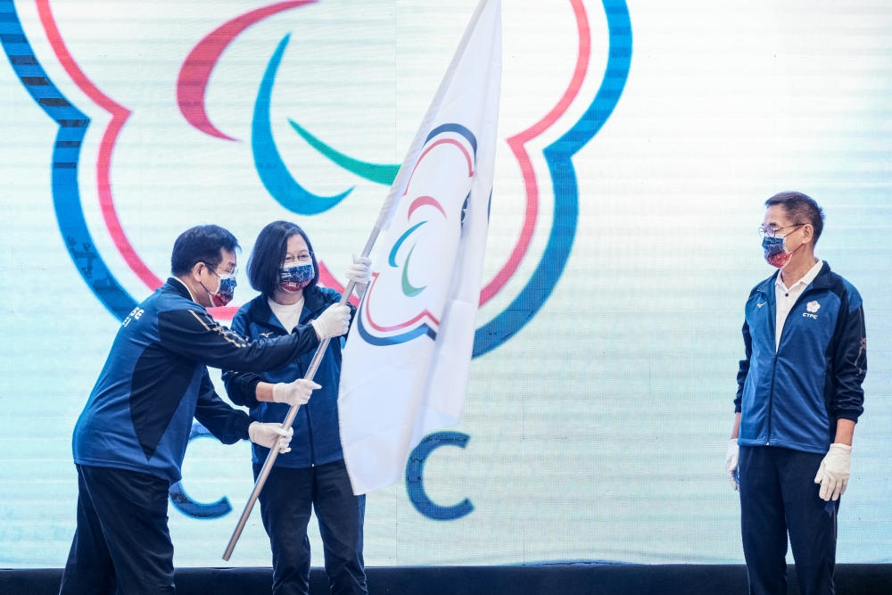 潘部長將團旗遞予總統授予王昭卿副團長， 祝福代表團旗開得勝。體育署提供。