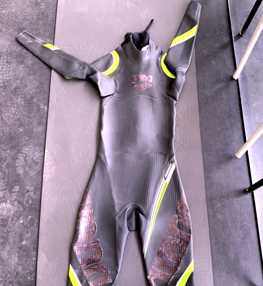 中華隊卓承齊趕工作美勞，用奇異筆將防寒衣上的Logo塗黑，以符合大會規範。 中華民國游泳協會國際組提供。