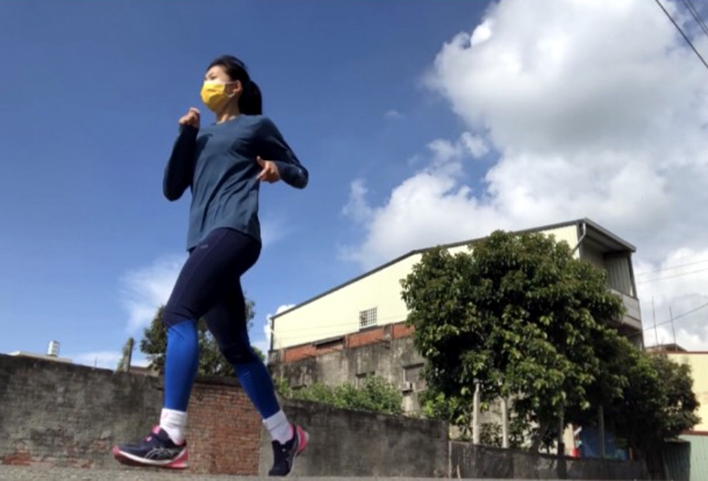 林美秀在住家附近的馬路邊做跑步訓練。